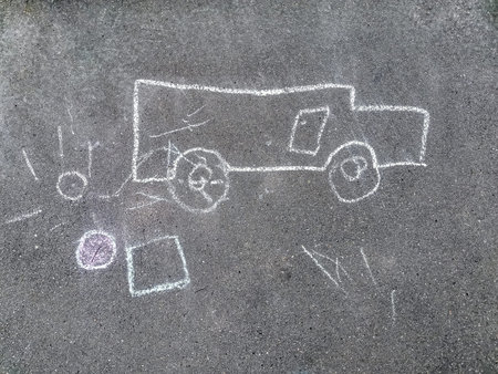 Children's drawing with chalk on the pavement. The child painted a white chalk car and the sun on...