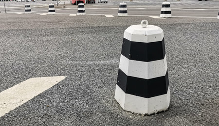 Close-up of a black and white concrete dividing post. Traffic organization, traffic rules, road...