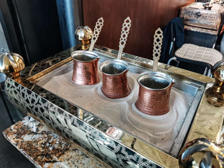 Three cezves on the sand for to prepare Turkish coffee. Traditional cezve 'Coffee pot' for Turkish coffee cooking on hot sand in the traditional oriental market.の写真素材