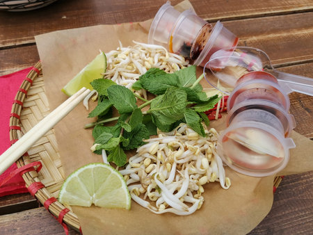 Lunch at a Vietnamese street cafe. Plate with additions to Vietnamese pho bo soup: sauces, garlic,...