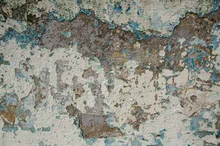 Old flaky plastered concrete wall. Texture of a stone wall with destroyed plaster with blue and...