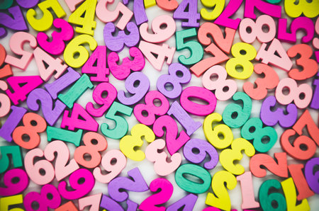 Bright multicolored background of wooden numbers from zero to nine. Top view, abstract colorful...
