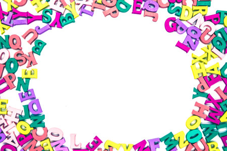 Multicolored background of wooden letters Latin alphabet with oval space in the center on white...