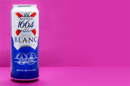 Large aluminum can of beer brands Kronenbourg 1664 Blanc owned by the Carlsberg Group on fuchsia background. Horizontal image, space for text on right. Moscow Russia - 10.21.2020のeditorial素材