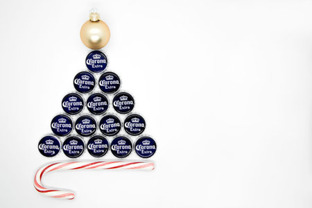 Christmas tree made of beer caps with Christmas ball and striped candy cane on white background. Space for text. New year party concept, postcard, banner. Moscow Russia - 11.26.2020のeditorial素材