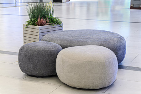 Sitting area in lobby, large shopping center - round ottoman fabric and artificial plants as decoration. Decoration of trading floors, exhibitions, recreation islands in public places.の写真素材