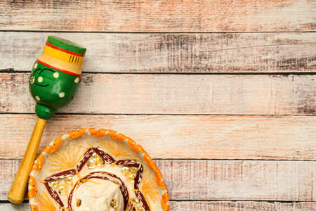 Festive Mexican headdress - sombrero on wooden boards and painted wooden maracas. Symbols of Mexico, background for the holiday Cinco de mayo. Top view. Space for textの写真素材