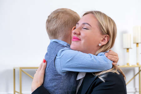 Gentle hugs of a blonde woman with her young son. Mom hugs the baby. Relationship between parents and children, Mother's Day.の写真素材