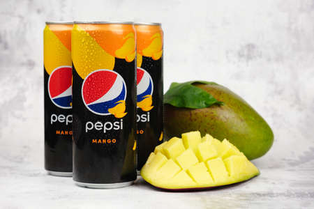 Three cans of pepsi drink with mango flavor and mango fruit. Expanding the range of PepsiCo products. Pepsi soda with an exotic taste without sugar and calories. Moscow, Russia - 11.01.2021のeditorial素材