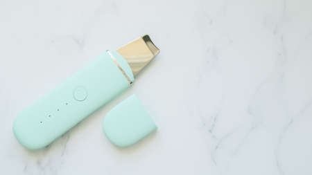 Electronic face skin cleansing scrubber on a light background. Facial pore cleansing tool, comedone blackheads, dead skin, oil and dirt extractor. Template for adding textの写真素材