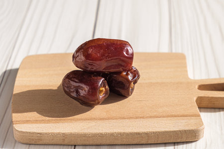 Dried dates in bright sunshine. The edible fruit of the date palm, valued for its richness in...