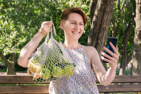 Attractive woman shows via video link purchases from farmers' market. The blogger broadcasts live...