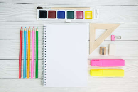 White notepad on a metal spiral and stationery on a wooden table. The concept of office work, back to school, stationery. Template for design, space to insert text or logo.の写真素材