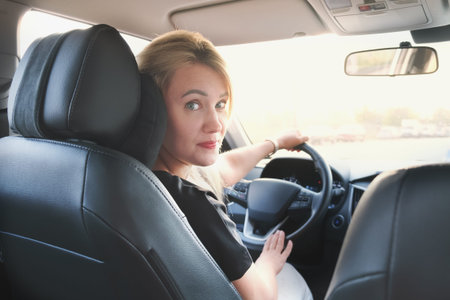 Young attractive woman drives a car. Beautiful blonde woman with long hair in a car while driving....