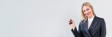 Woman manager in business clothes is holding the keys to car and smiling while looking at the...