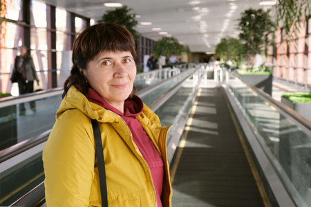 Portrait of an elderly woman at the airport. Mature brunette woman at the airport stands on a...