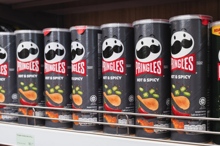 Shelf in the supermarket with Pringles chips with spicy taste. Adaptation of the global brand to local markets. Pringles in the Asian market. Phuket, Thailand, 01.28.2023のeditorial素材