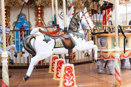 Children's vintage carousel with figures of horses. A working carousel without people. Colorful fair carousel on the square.の写真素材