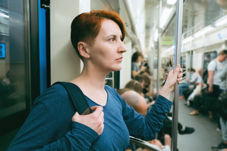 Middle-aged woman with short hair rides in a subway car. Tired woman returns from work. Use of...