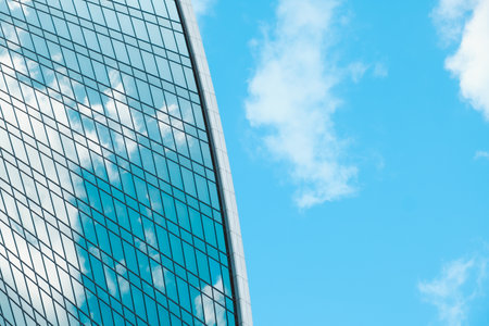 View of glass facade of skyscraper and blue sky with white clouds. Modern architecture, urban space. abstract background.の写真素材