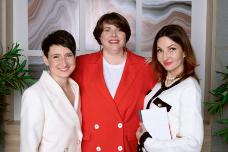 Three women business partners smile and look at the camera. Portrait of middle-aged female partners....
