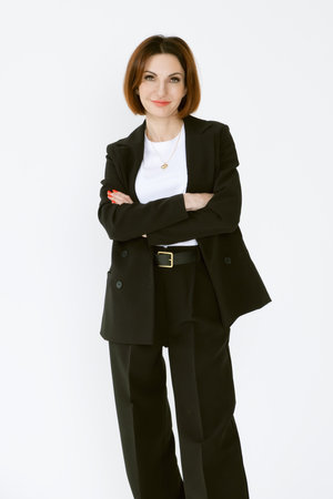 Portrait of a confident business woman in a black pantsuit and a white blouse on a white background. Portrait of a middle-aged woman in black trousersの写真素材
