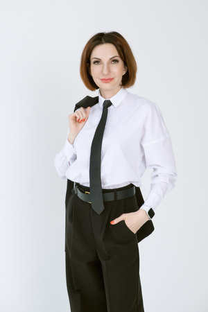 Portrait of a confident business woman in a black pantsuit and a white blouse on a white background. Portrait of a middle-aged woman in black trousersの写真素材