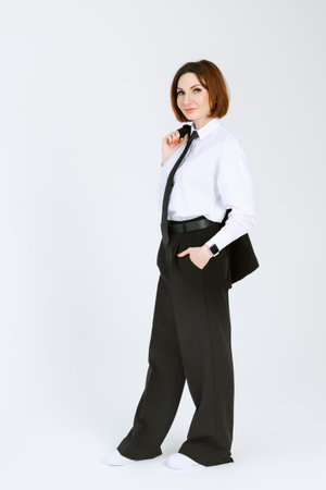 Portrait of a confident business woman in a black pantsuit and a white blouse on a white background. Full-length portrait of a middle-aged woman in black trousersの写真素材