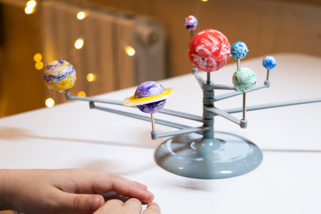 Preschooler child is making a solar system project. A child makes a craft on the subject of astronomy. Education and development of children.の写真素材