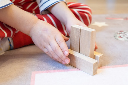 The child plays with wooden bars, making shapes out of them. Eco-friendly toys for children made of natural wood.の写真素材