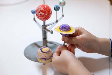 Preschooler child is making a solar system project. A child makes a craft on the subject of astronomy. Education and development of children.の写真素材