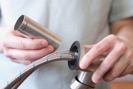 Demonstration of a threaded metal sleeve for installing and securing a kitchen faucet. Preparing to replace the kitchen faucet.の写真素材