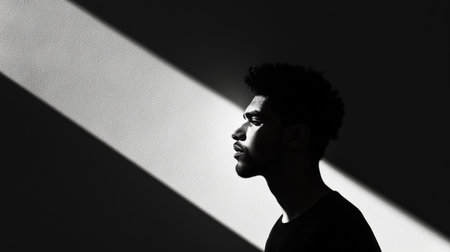 Dramatic silhouette of a man casting a shadow in bright light, adding depth and mysteryの素材