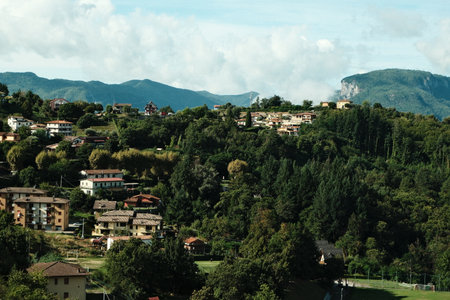 Vibrant hillside homes nestled among lush greenery in a scenic mountainous landscape during daylightの写真素材