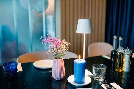 Elegant dinner table setting with flowers, candles, and decorative items in a cozy restaurant...