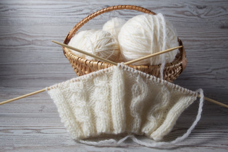 Ball of yarn and knitting on a wooden table