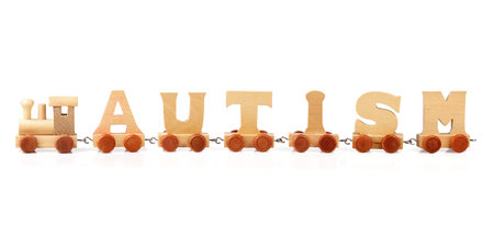 Autism spelled out in wooden train letters on white background の写真素材