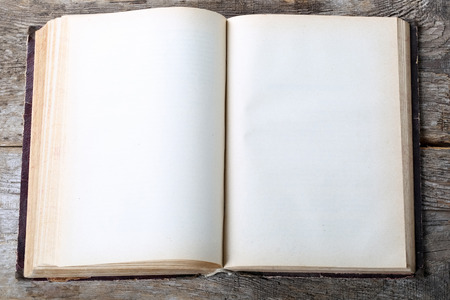 Vintage book, open, on old wooden tableの写真素材