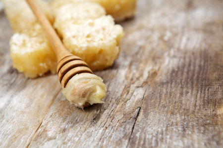 Honey with comb on wooden background