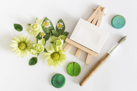 Flowers and leaves with watercolor and paintbrushon white  background. Overhead view. Flat lay
