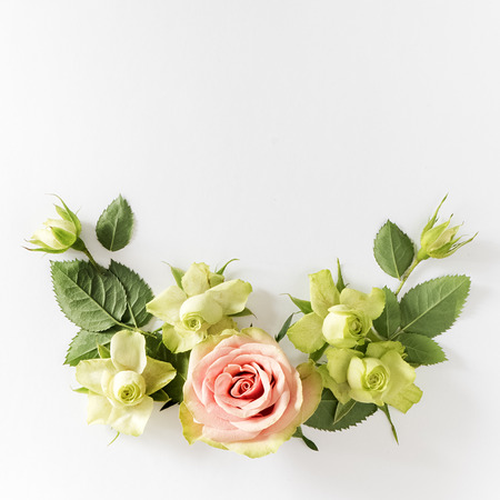 Frame  with  roses, green flowers and leaves on white background. Flat lay, top viewの写真素材