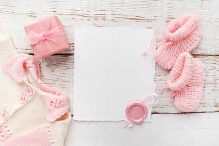 Baby girl clothes with blank card on wooden background. Flat lay. Owerhad viewの写真素材