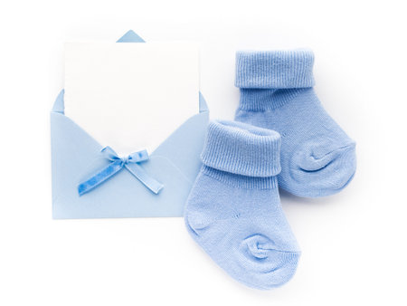 Small boy blue socks, blank card in evelop on white background. Flat lay.の写真素材