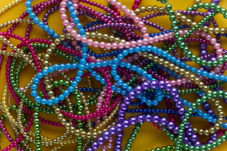 Background of large amount marid gras bead on yellowの写真素材