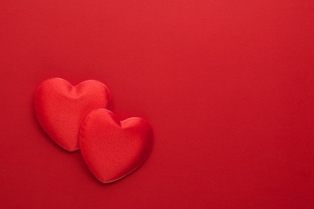 Two decorative hearts are on red paper. Flat lay.の写真素材