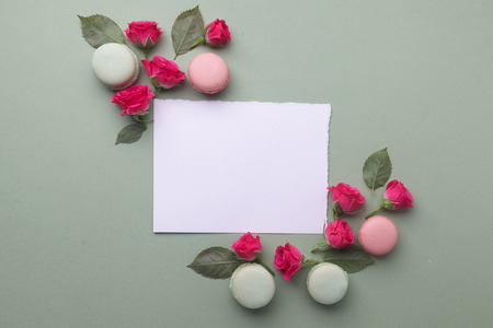 Romantic lovely frame from macarons and roses on green background. Flat lay. Top viewの写真素材