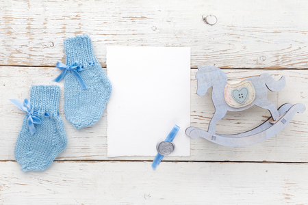 Greeting children form with blue booties and wooden horse. Flat layの写真素材