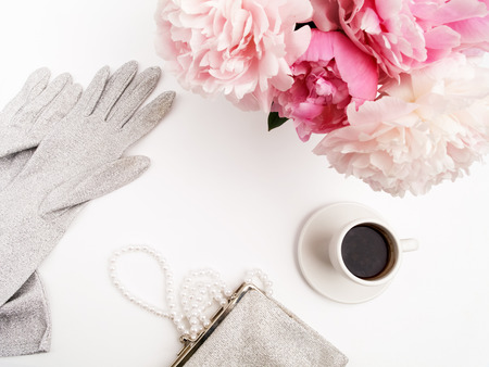 Still life with cup of coffee, peonies flowers and gloves on light table. Flat lay. Top viewの写真素材