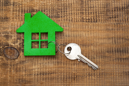 Symbol of the house with silver key on wooden backgroundの写真素材