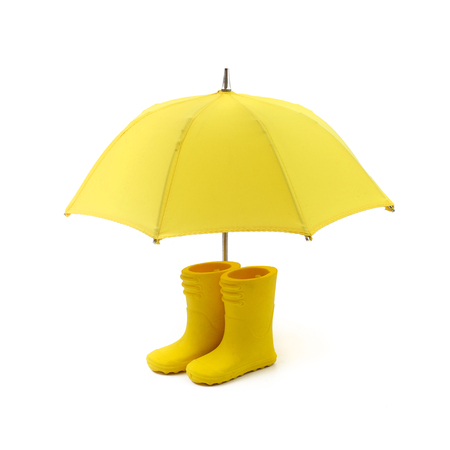 A pair of yellow rain boots and a umbrella on a whiteの写真素材